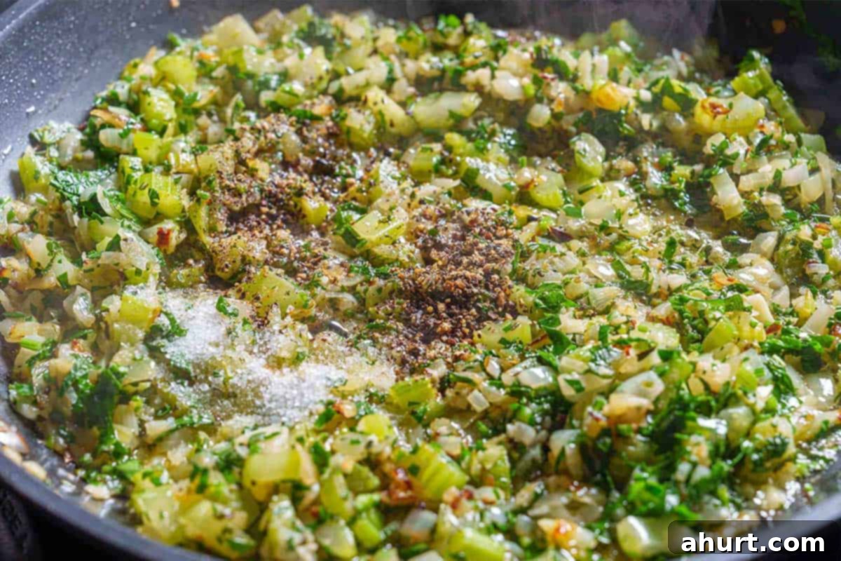 Irresistible Sausage Stuffing 6 Step 3: The image shows onions, celery, and garlic cooked over medium heat until they are softened and translucent.