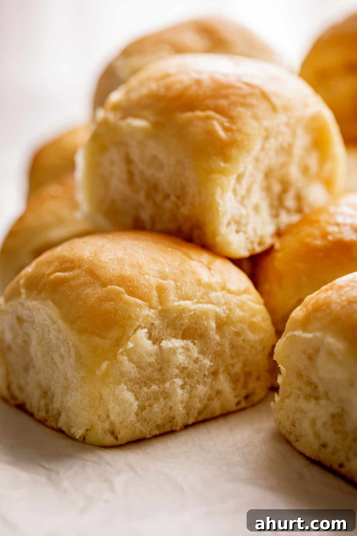 Pillowy Soft Dinner Rolls Hand Kneaded And Egg Free 9 A perfectly stacked pile of fluffy and soft dinner rolls, showcasing their inviting golden crust and tender interior.