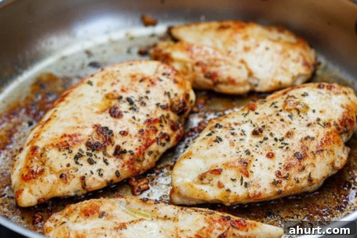 Golden Mozzarella Chicken Bake 6 Searing the seasoned chicken breasts to a perfect golden brown in an oven-safe skillet.