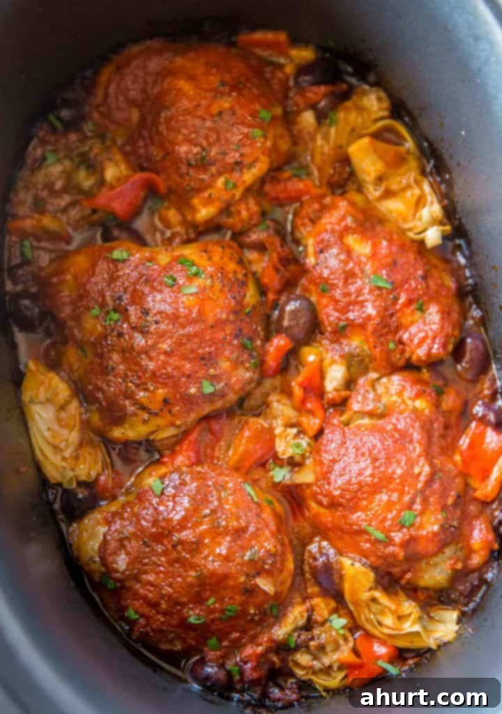 Tender Slow Cooker Mediterranean Chicken with olives, artichokes, and roasted red peppers served in a pan