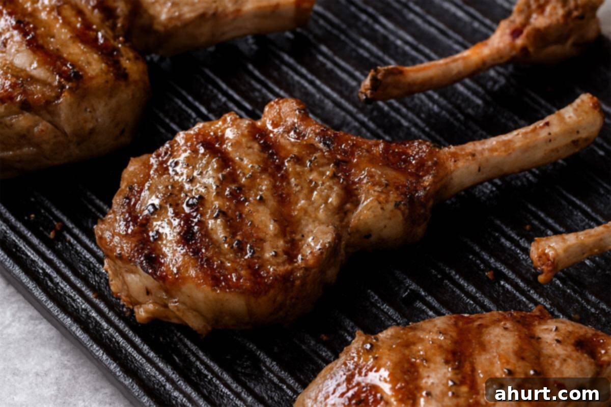 Traditional Greek Lamb Chops 7 Perfectly seared Greek Lamb Chops in a cast iron skillet, golden brown with char marks.