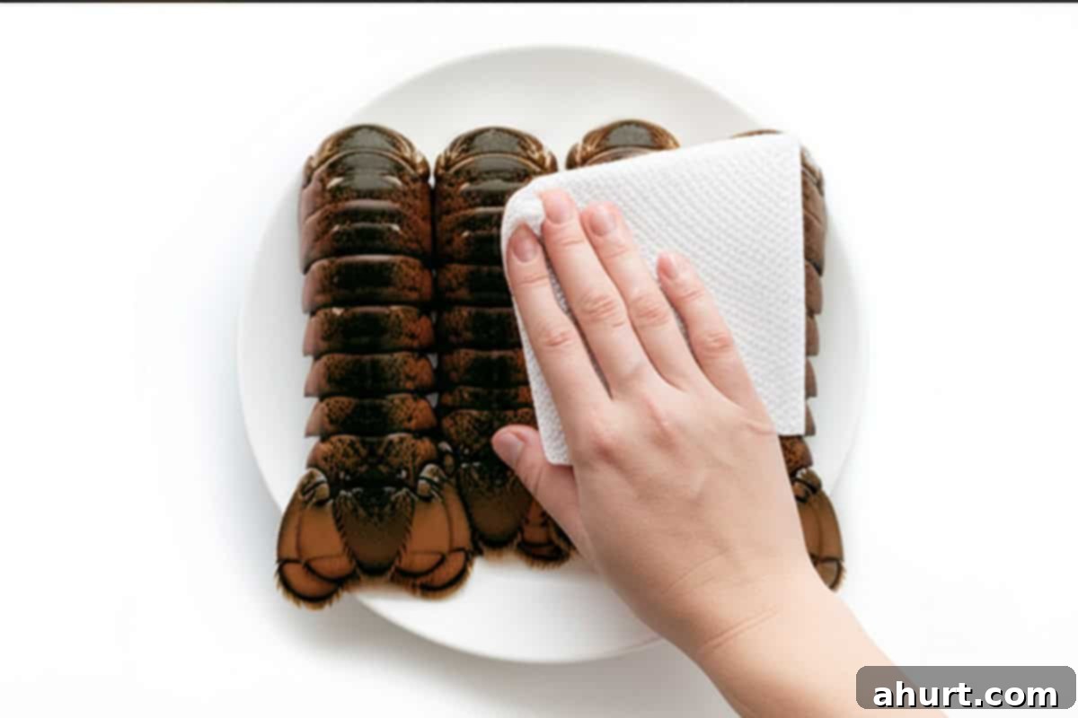 Succulent Broiled Lobster Tails 5 Hand with paper towel and lobster tails.