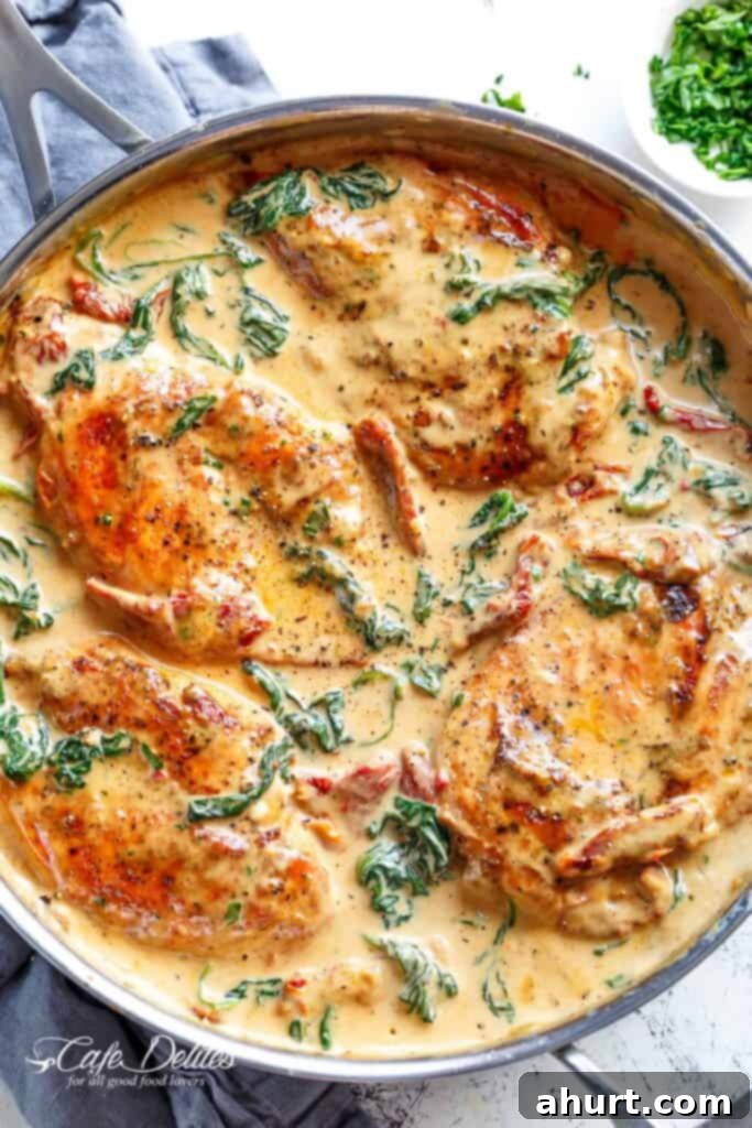 Decadent Tuscan Chicken 2 Creamy Tuscan Chicken with parmesan spinach sauce in a pan, ready to serve