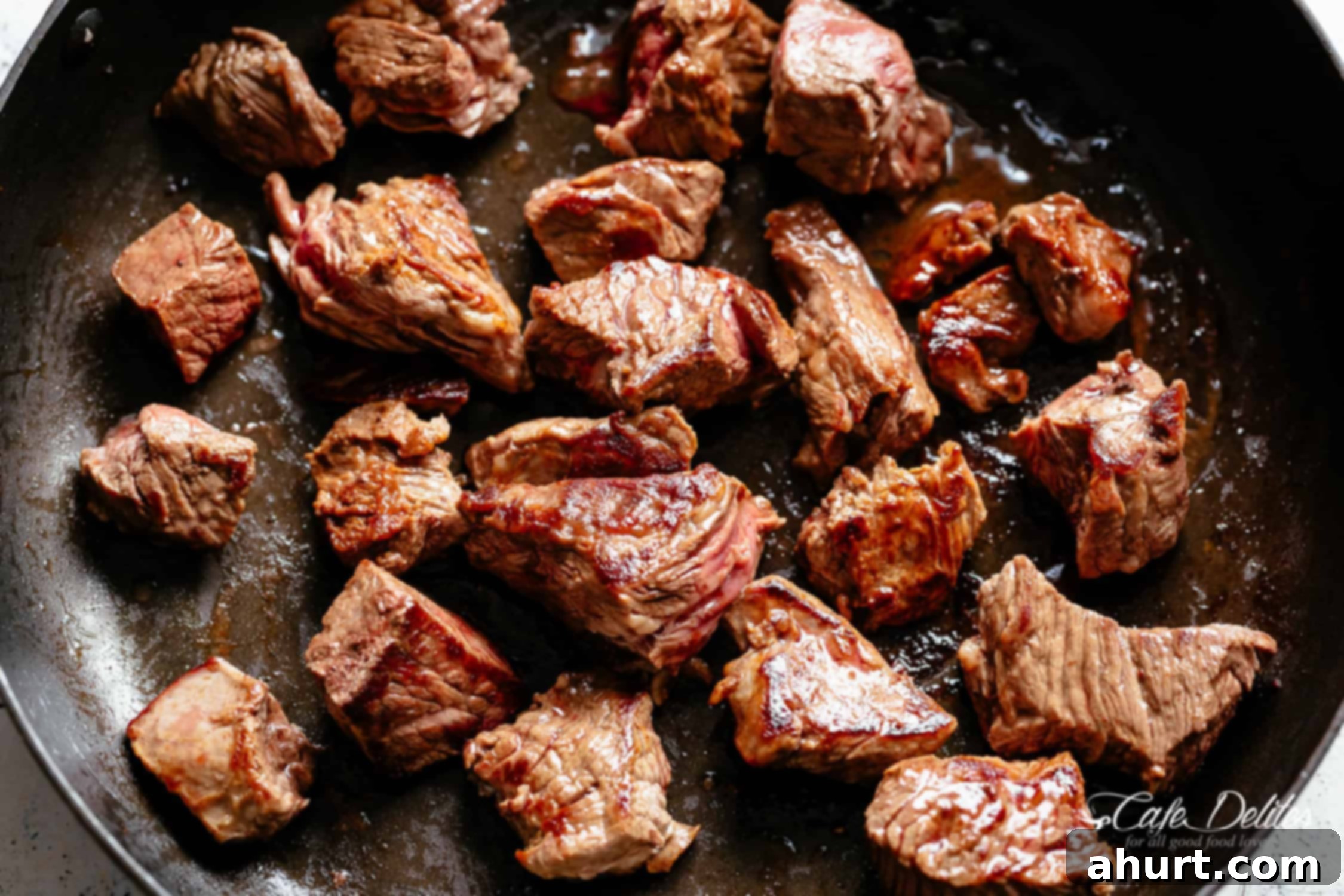 Beef Bourguignon by Julia Child 5 Seared beef pieces in bacon grease in a black pan