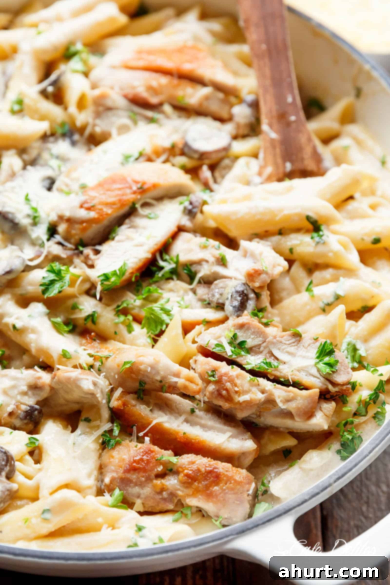 Velvet Chicken Alfredo Pasta 3 A close-up shot of creamy garlic parmesan chicken alfredo in a white bowl, ready to be enjoyed.