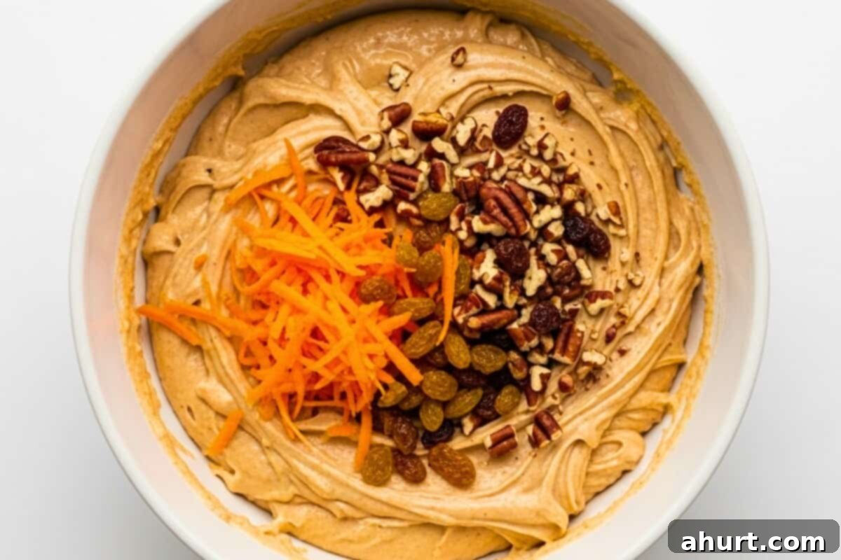 Golden Spiced Carrot Cake 7 Fold in the grated carrots, nuts and raisins to the wet mixture