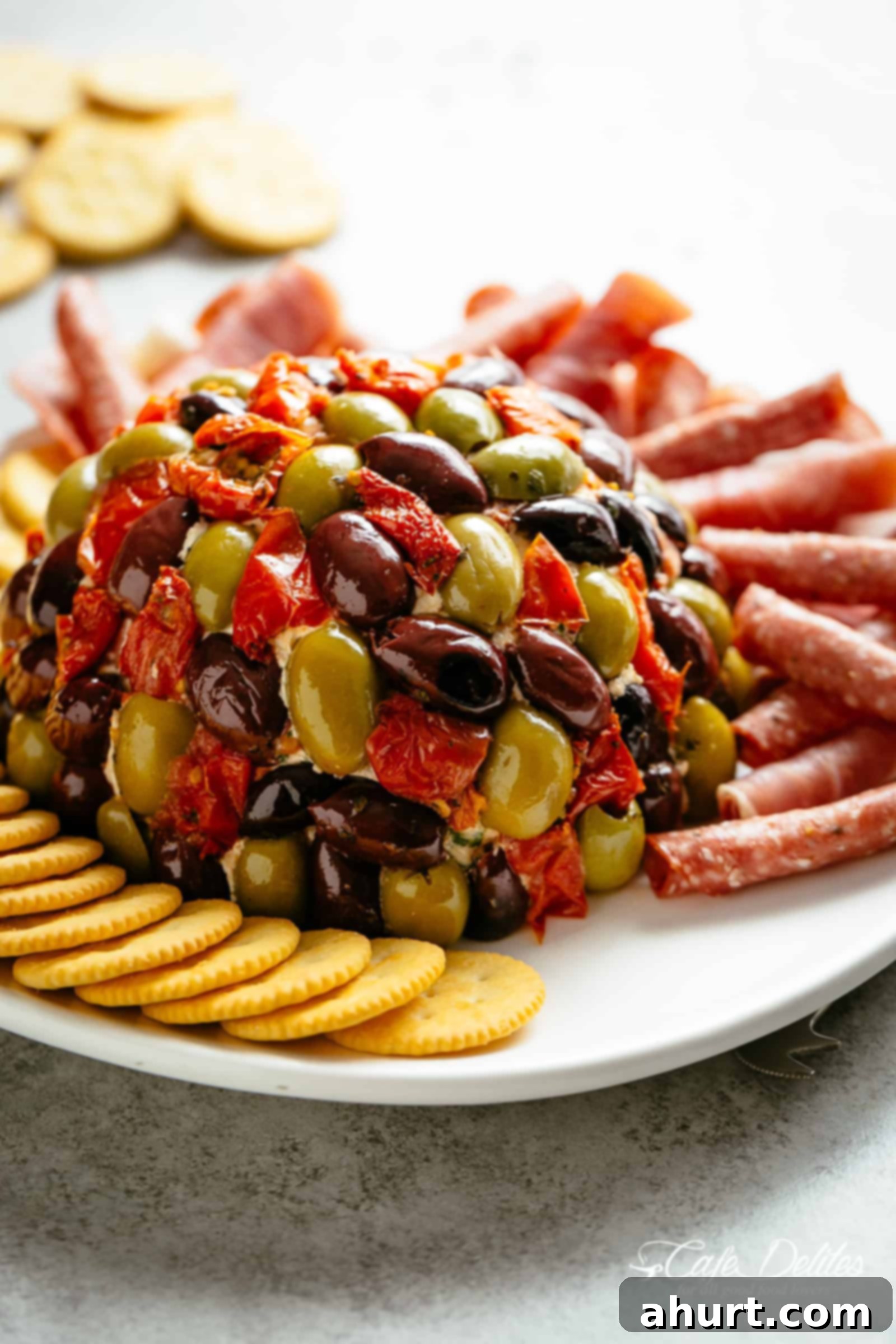 Cheese Ball Antipasto | cafedelites.com Antipasto Cheese Ball on a plate decorated with biscuits and other items, ready for serving