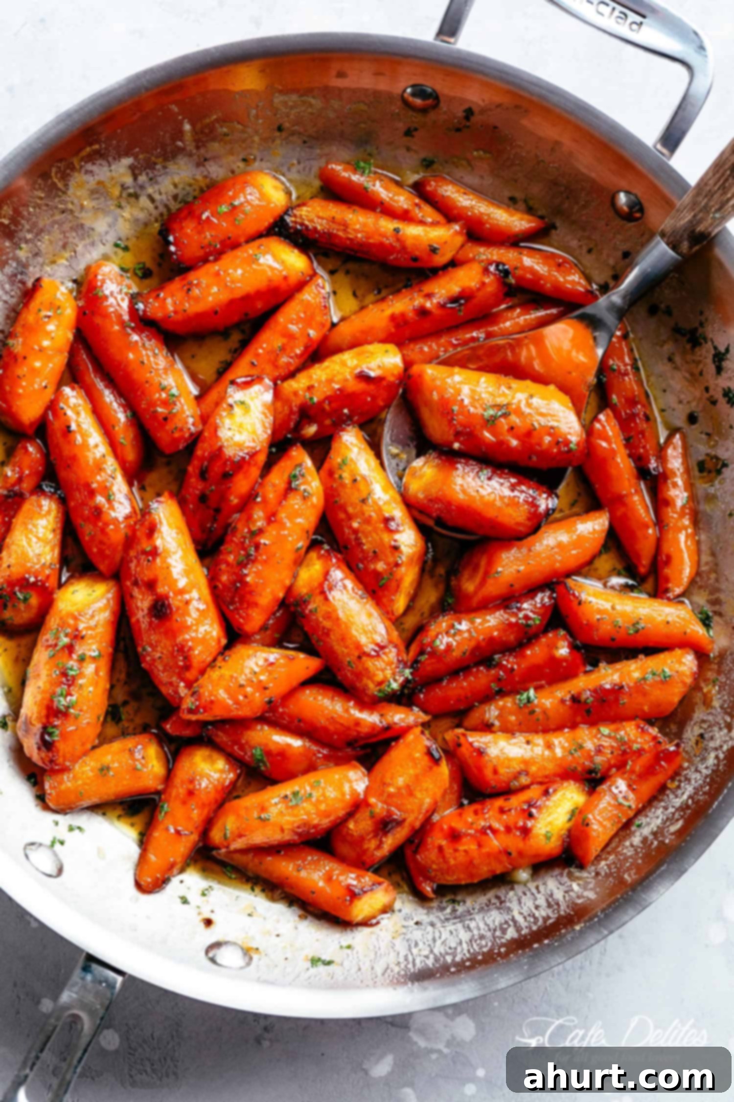 Golden Honey Garlic Butter Carrots 2 Top view of Honey Garlic Butter Roasted Carrots in a steel pan with a sprinkle of green garnish.