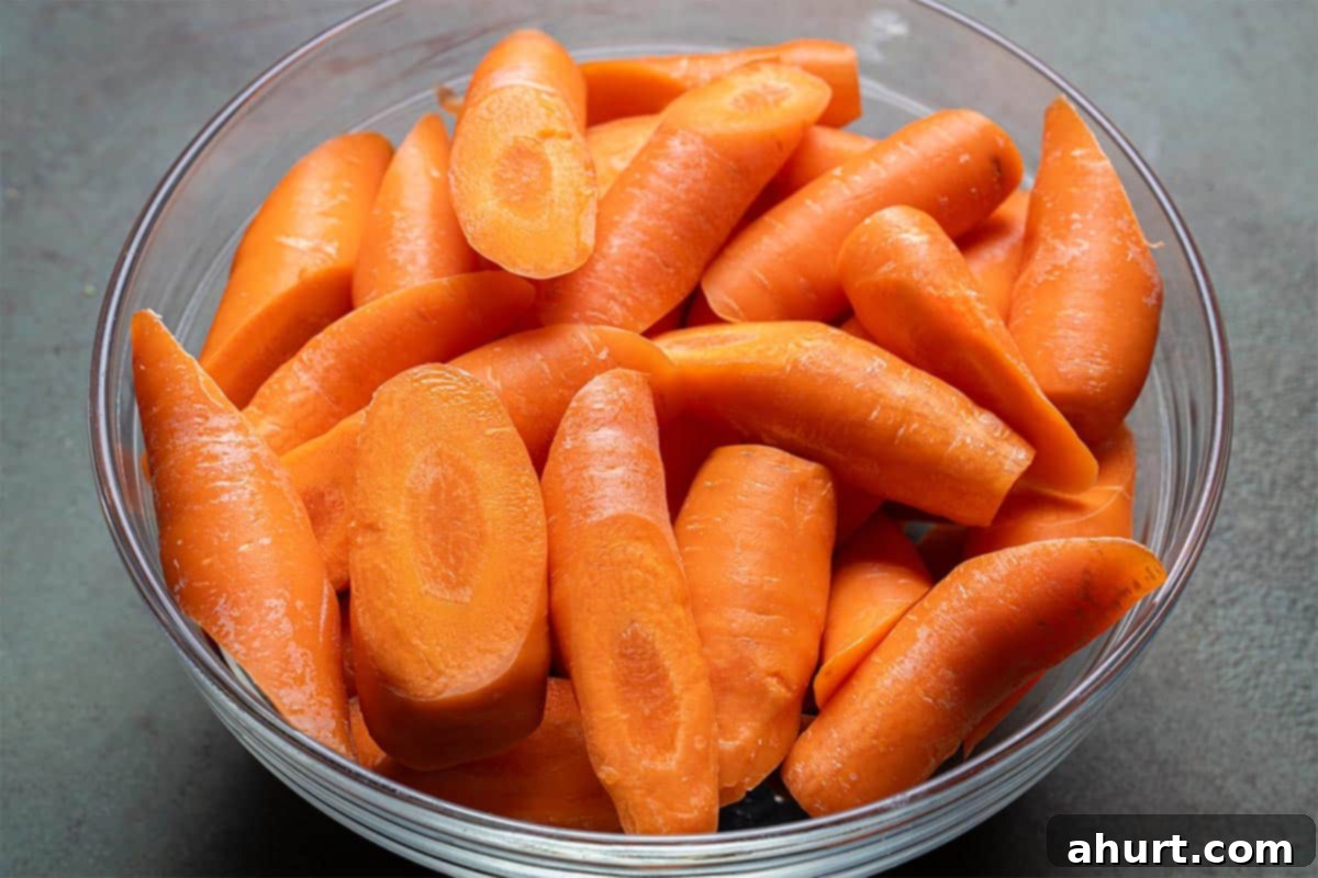Golden Honey Garlic Butter Carrots 5 Image of carrots with trimmed ends, cut into thirds, placed in a clear bowl.