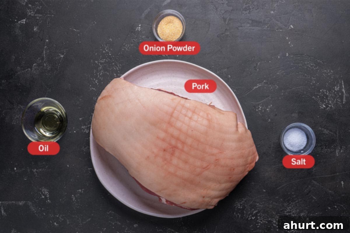 Golden Crackle Pork Roast 2 Selection of key ingredients for crispy pork roast, including boneless pork shoulder with rind, olive oil, garlic powder, and coarse sea salt.