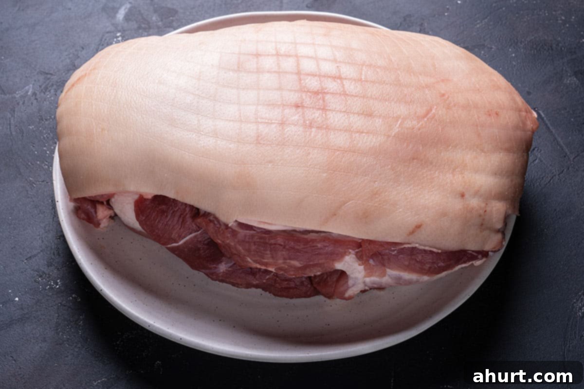 Golden Crackle Pork Roast 3 Pork shoulder with rind on, laid out flat to dry in a tray, crucial for crispy crackling.