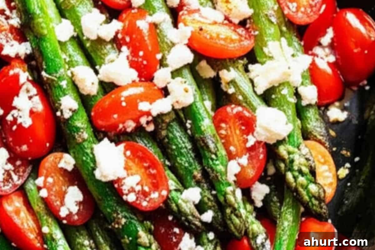 Effortless Lemon Garlic Asparagus 7 Cooked asparagus topped with cherry tomatoes and feta cheese.