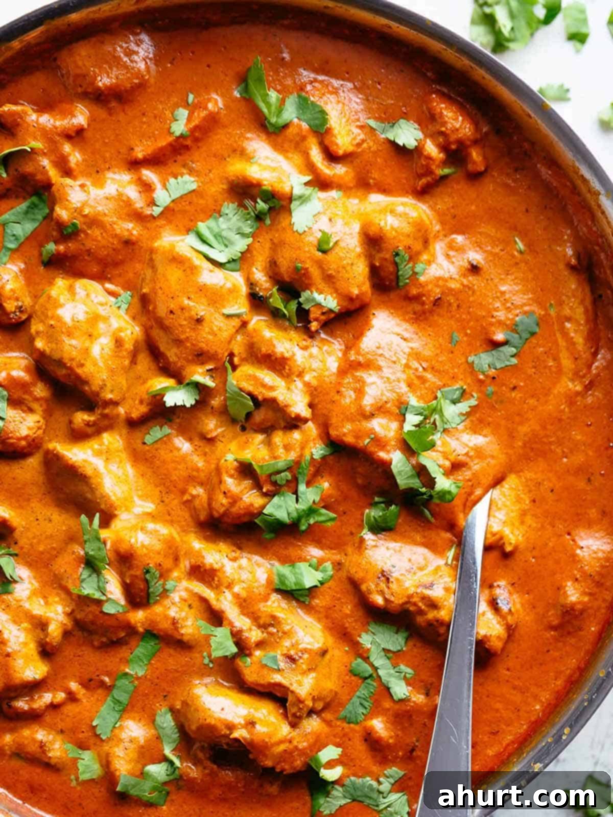 Rich and Creamy Chicken Tikka Masala 2 chicken tikka masala in a bowl garnished with fresh parsley, served beside rice with naan