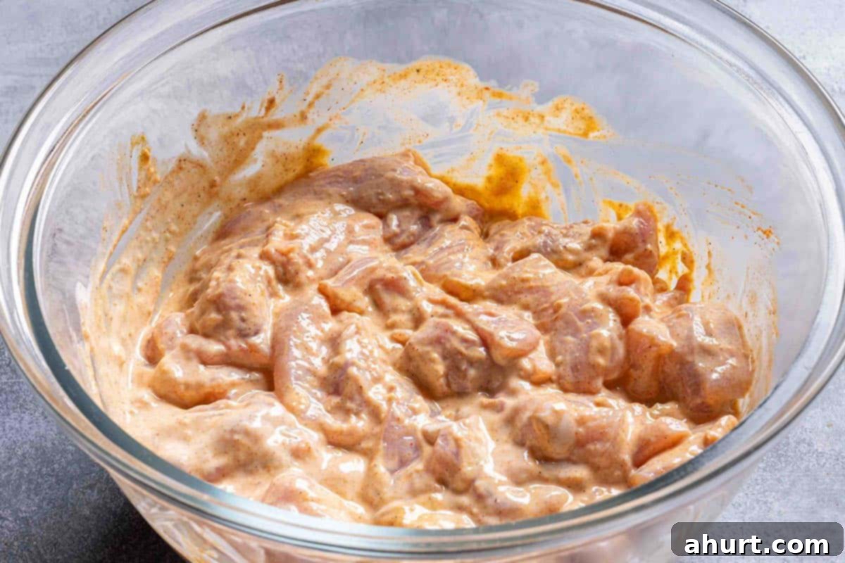 Rich and Creamy Chicken Tikka Masala 4 chicken thighs in a creamy marinade sitting in a glass bowl