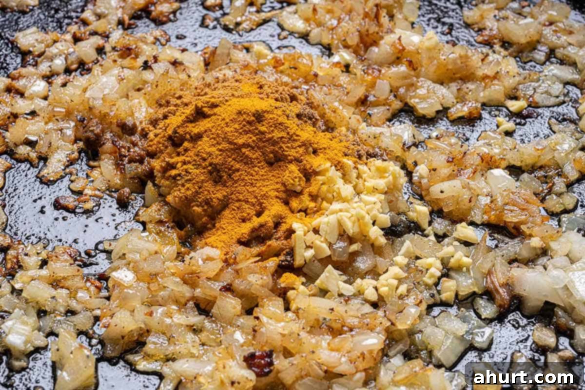 Rich and Creamy Chicken Tikka Masala 6 finely diced onions, grated garlic and grated ginger, garam masala, ground cumin, turmeric, and ground coriander all in a large black skillet