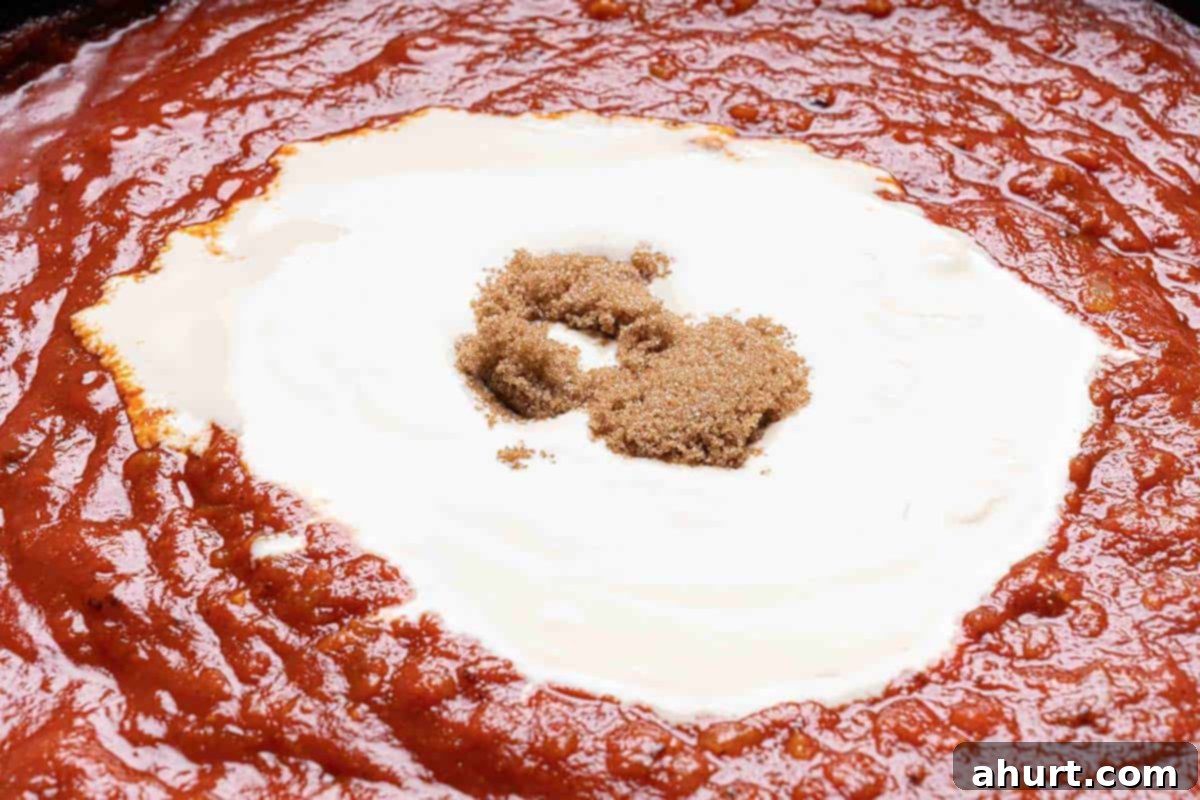 Rich and Creamy Chicken Tikka Masala 7 red sauce mixed with onions and spiced in a black skillet