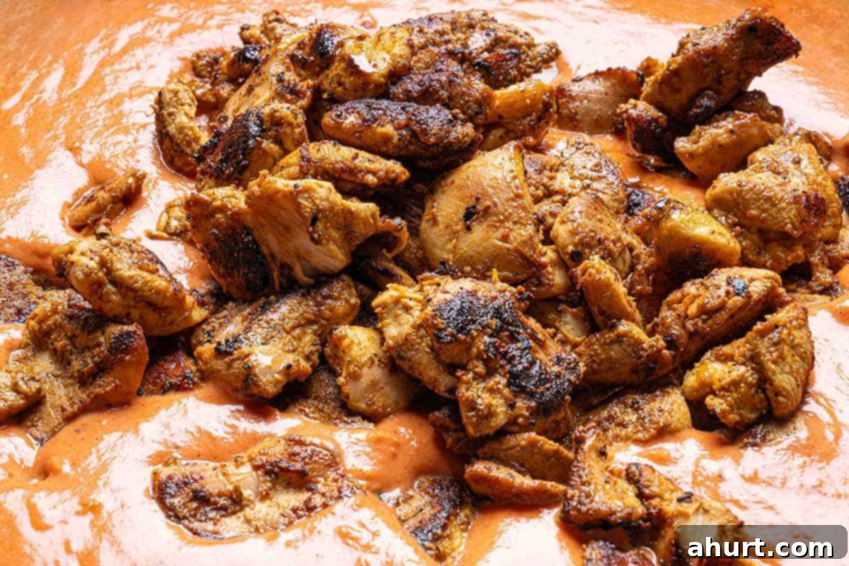 Rich and Creamy Chicken Tikka Masala 8 creamy tikka masala sauce with seared chicken being poured in