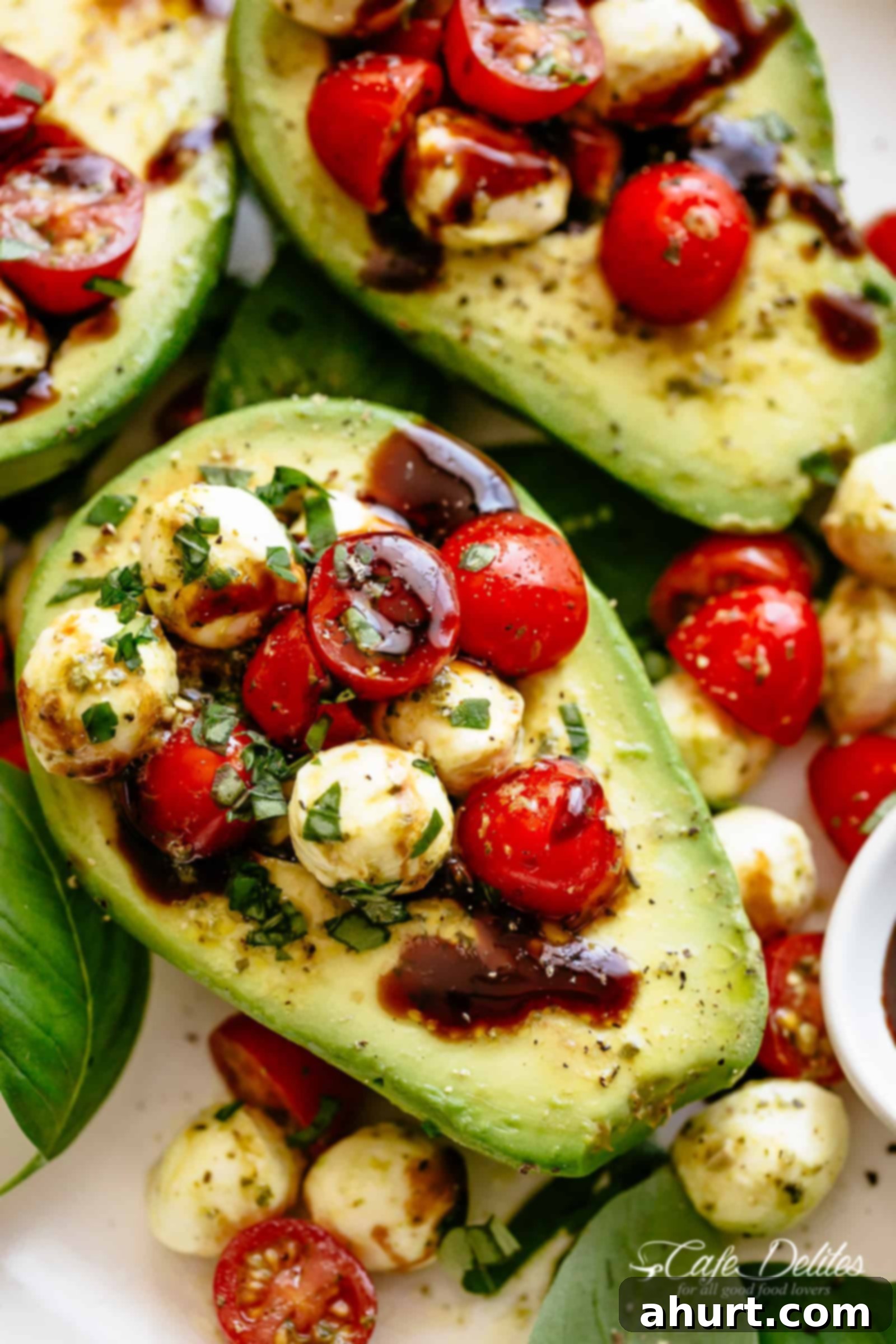 Pesto Caprese Stuffed Avocado | cafedelites.com Basil Pesto Caprese Stuffed Avocado drizzled with balsamic glaze, perfect for a light lunch or snack. Fresh ingredients like sweet grape tomatoes, mozzarella balls, and basil pesto are spooned into creamy avocado halves.