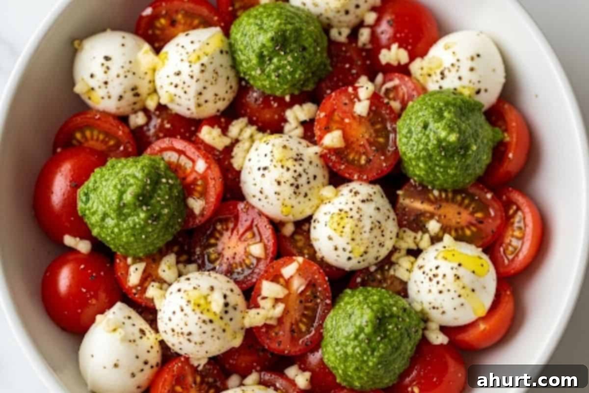 Caprese Avocado Boats 3 In a medium bowl, combine halved tomatoes, mozzarella balls, basil pesto, minced garlic, and olive oil; season with salt and pepper, then toss gently.