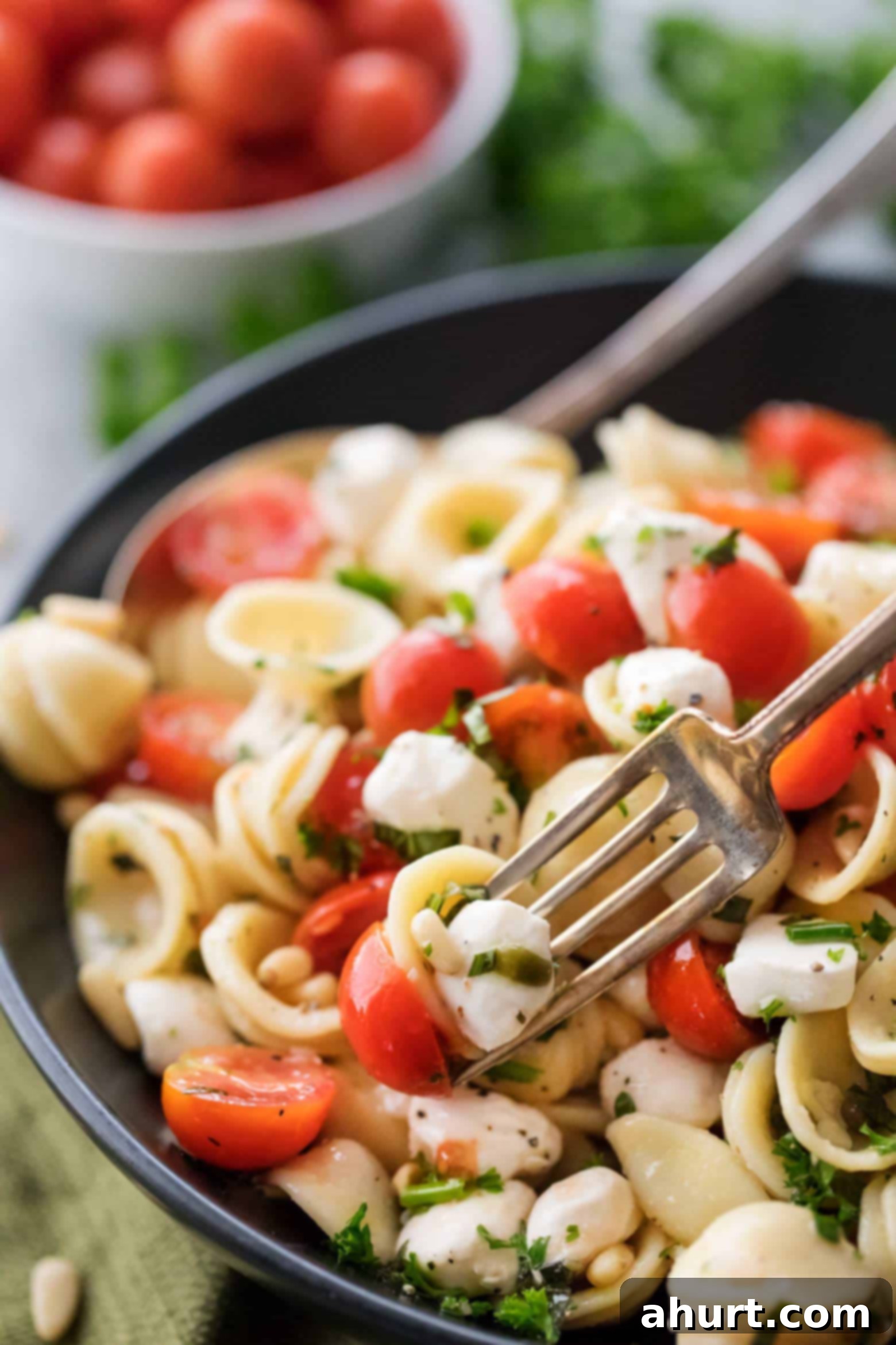 Caprese pasta side dish! | cafedelites.com A beautifully presented bowl of Caprese pasta salad, ready to be served, highlighting the fresh ingredients and vibrant colors.