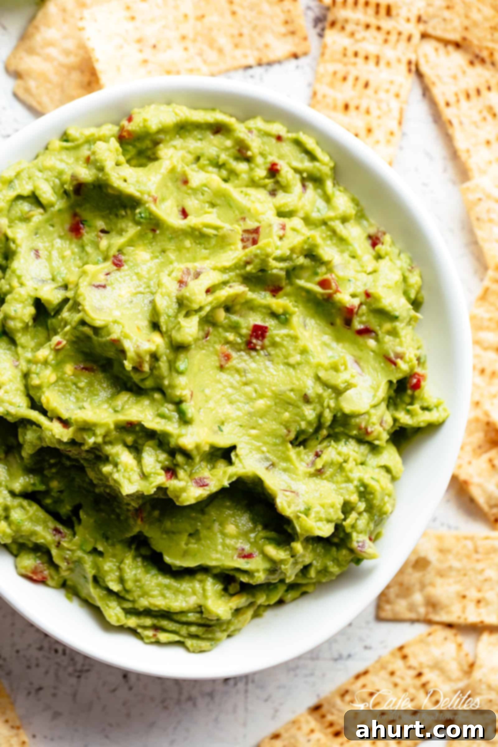 Creamy Guacamole! | cafedelites.com Top view of The best, creamy Guacamole is so easy to make and better than anything found in a jar! Homemade Guacamole takes minutes to make and is so incredibly delicious! Perfect for a party as an appetizer OR just a simple snack! Use as a topping for your favourite fajitas, tacos and even carnitas.