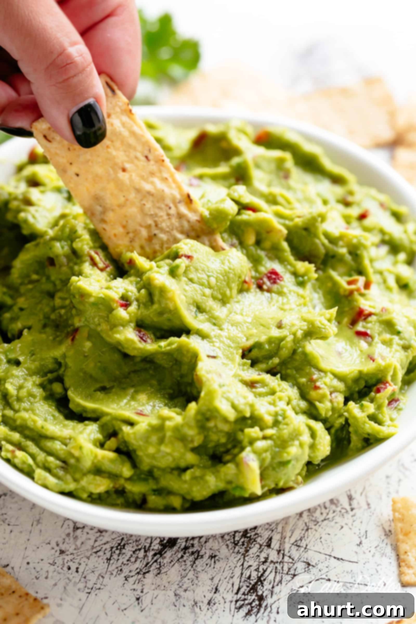 Guacamole is perfect for a party as an appetizer OR snack! | cafedelites.com Homemade Guacamole for fajitas, tacos and carnitas in a white bowl