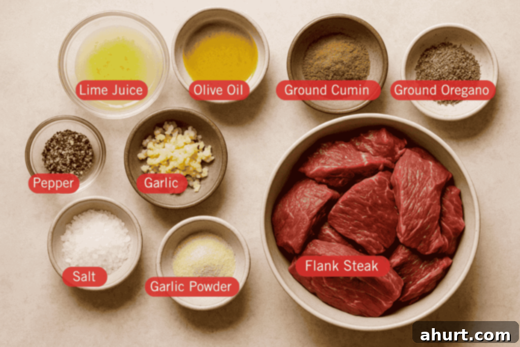 Authentic Carne Asada Recipe 2 A flatlay photo of labeled carne asada ingredients on a light beige surface. At the center right is a bowl of raw flank steak slices. Surrounding it are small bowls containing lime juice, olive oil, ground cumin, ground oregano, minced garlic, garlic powder, salt, and cracked black pepper.