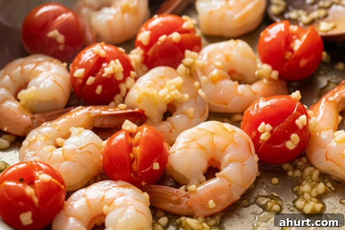 Creamy Pesto Alfredo Shrimp 4 Garlic added to the shrimp and tomatoes.