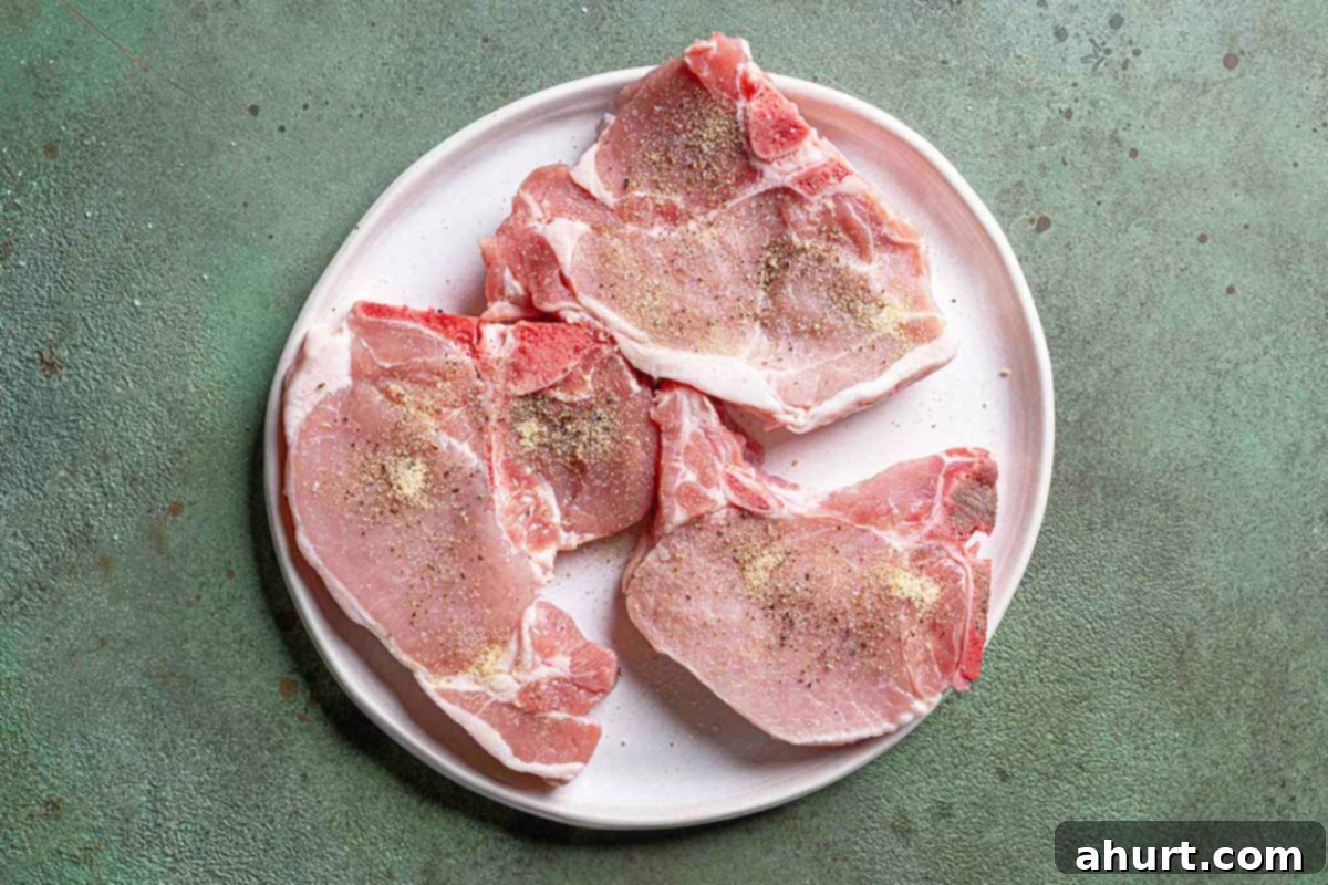 Quick Beef Noodle Stir-fry 4 Pork chops on a white plate with a green textured background, seasoned with salt and pepper.