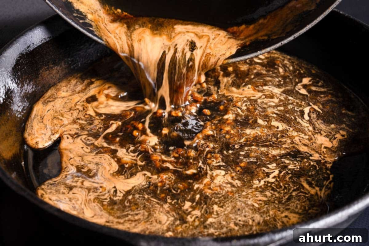 Quick Beef Noodle Stir-fry 7 Honey garlic sauce being poured from a bowl into a pan with browned bits from seared pork chops.