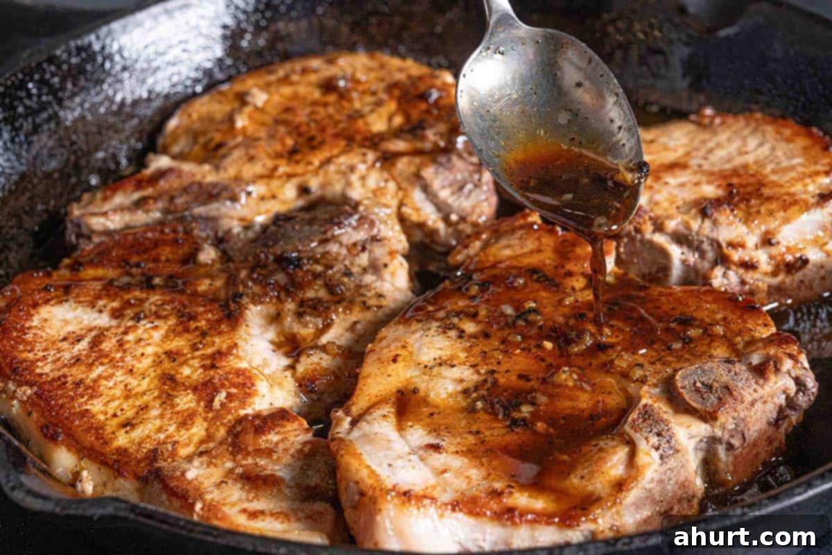 Quick Beef Noodle Stir-fry 8 Pork chops sizzling in a black pan, being doused in honey garlic sauce with a silver spoon.