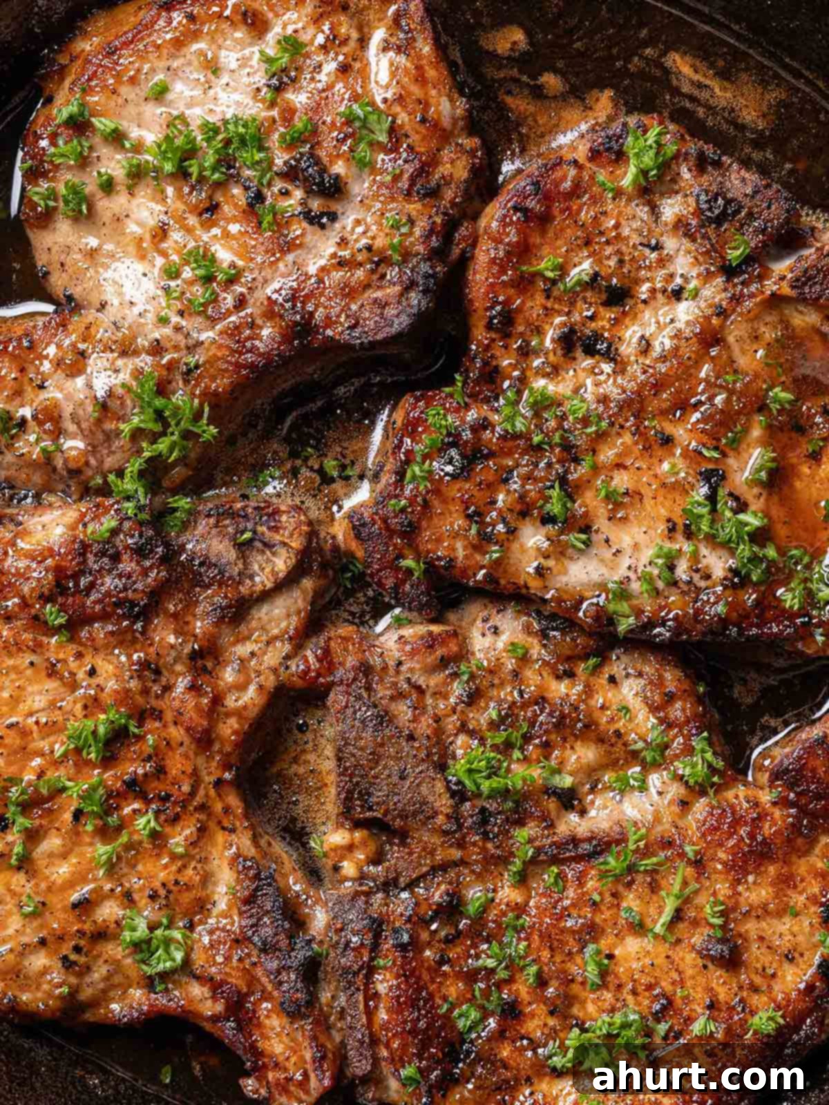 Quick Beef Noodle Stir-fry 9 Finished juicy honey garlic pork chops in a black pan, garnished with parsley.