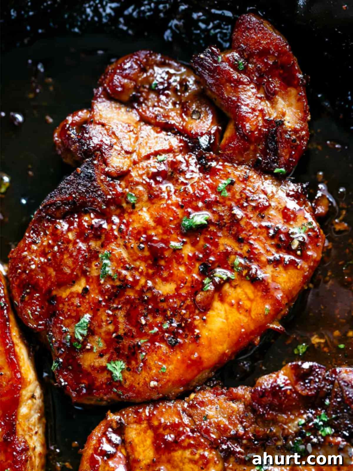 Quick Beef Noodle Stir-fry 10 Finished juicy honey garlic pork chops in a black pan, garnished with parsley.