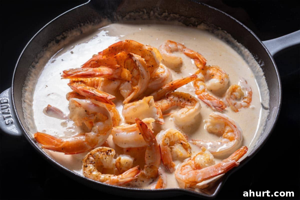 Luscious Low Carb Creamy Garlic Parmesan Shrimp 7 Shrimp are being added to the cream.