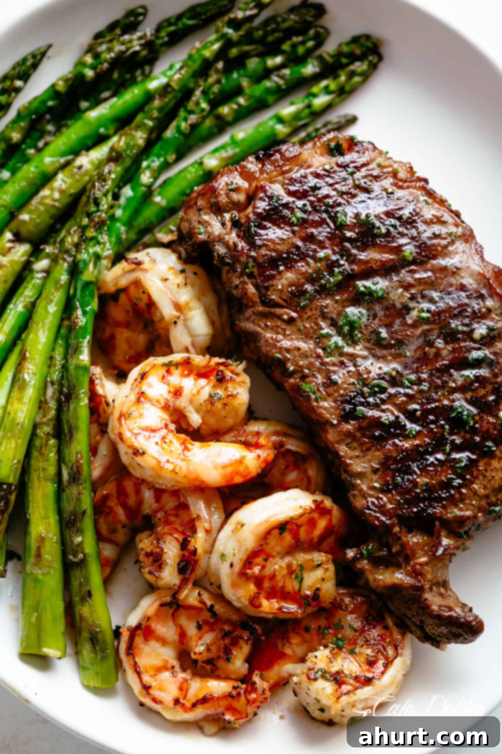 Steak & Shrimp slathered in garlic butter makes for the BEST steak recipe! | cafedelites.com Grilled Steak & Shrimp on a plate