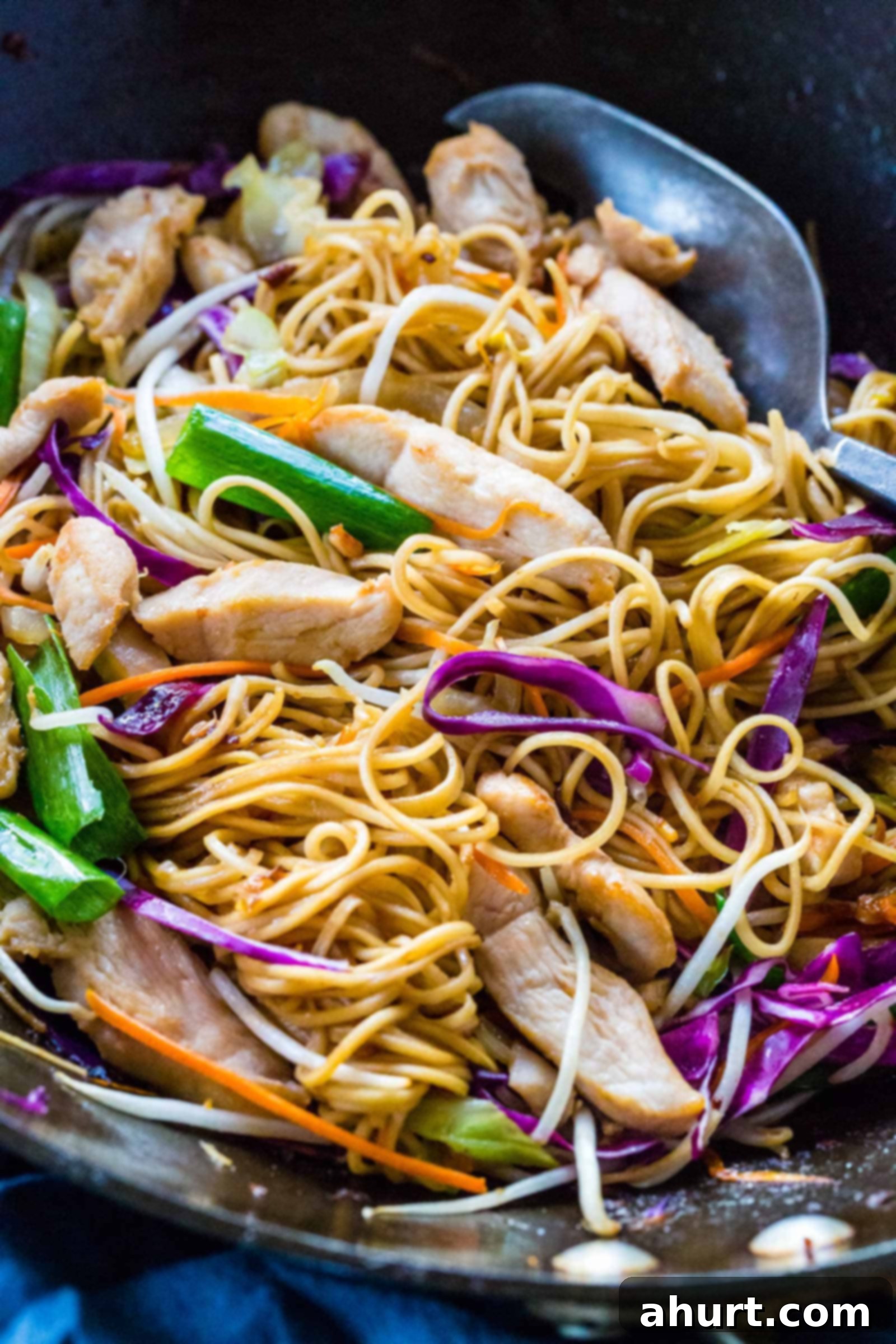 Savory Chicken Noodle Stir-Fry 12 Wok spatula mixing chicken chow mein in a pan