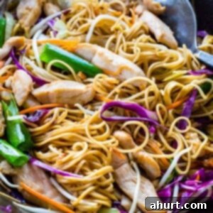 Savory Chicken Noodle Stir-Fry 13 Wok spatula mixing chicken chow mein in a pan