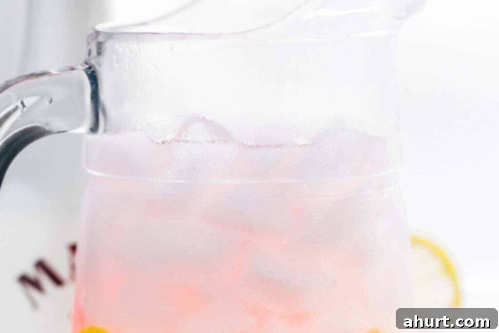 Pink Vodka Lemonade Perfection 3 Step 1: Combining vodka, cranberry juice, Malibu, and lime juice in a large pitcher filled with ice.