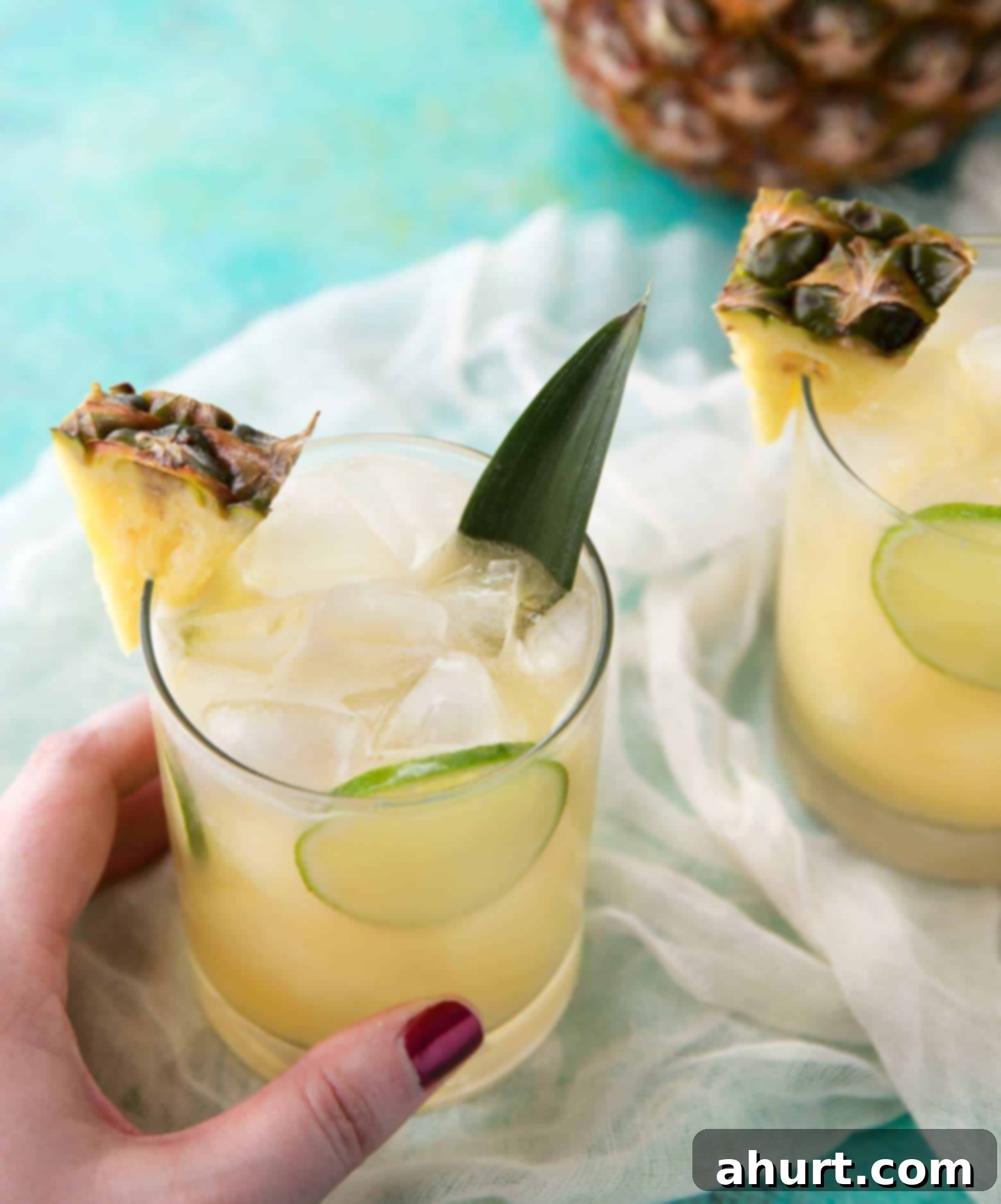 Pineapple Rum Punch is a refreshing cocktail to enjoy in your own home! | cafedelites.com Top-down view of a vibrant Tropical Pineapple Rum Punch with fresh fruit garnishes, ready to be enjoyed.