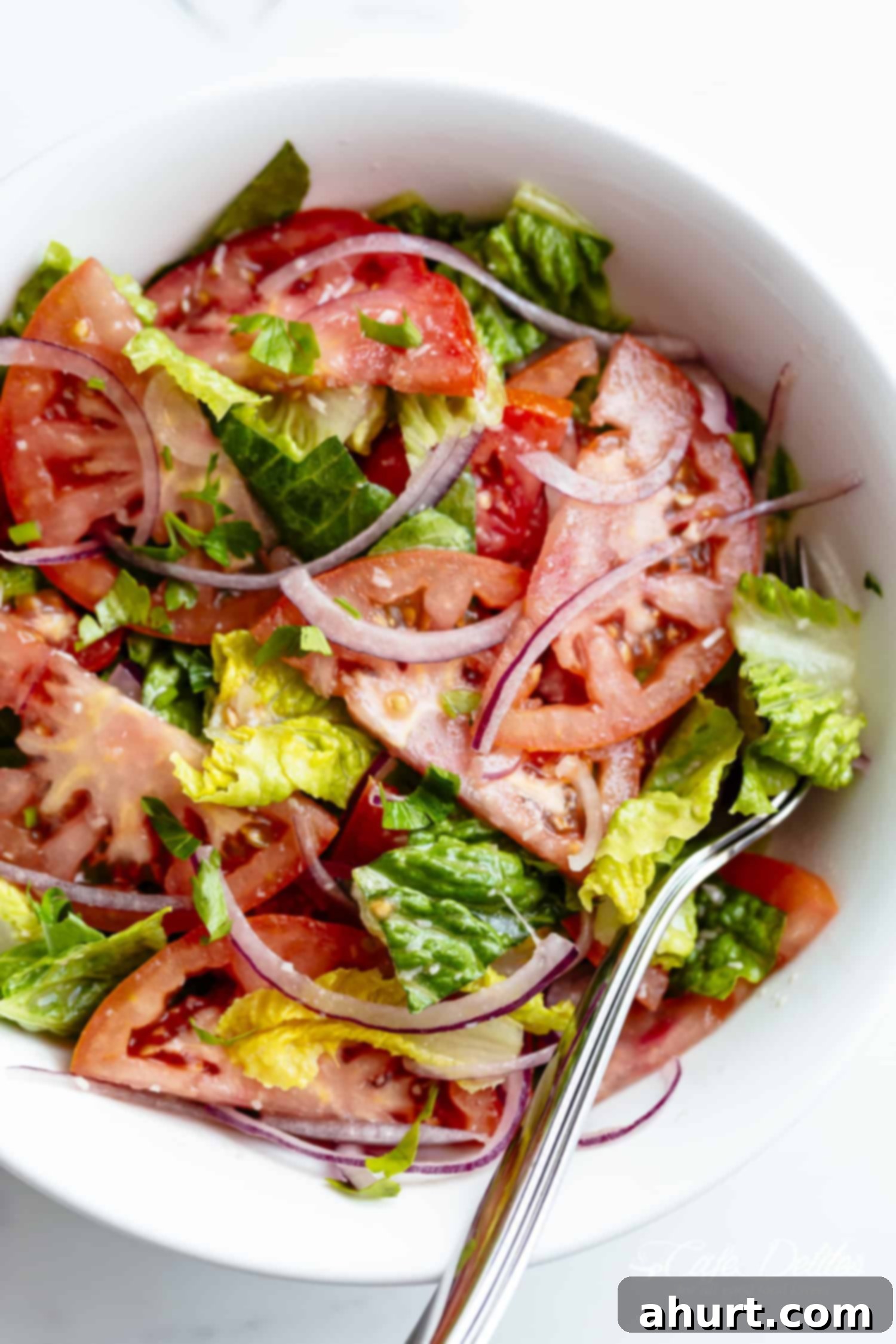 No-Fuss Tomato Salad 2 Fresh and vibrant Easy Tomato Salad with Lemon Parmesan Vinaigrette in a white bowl, garnished with fresh herbs