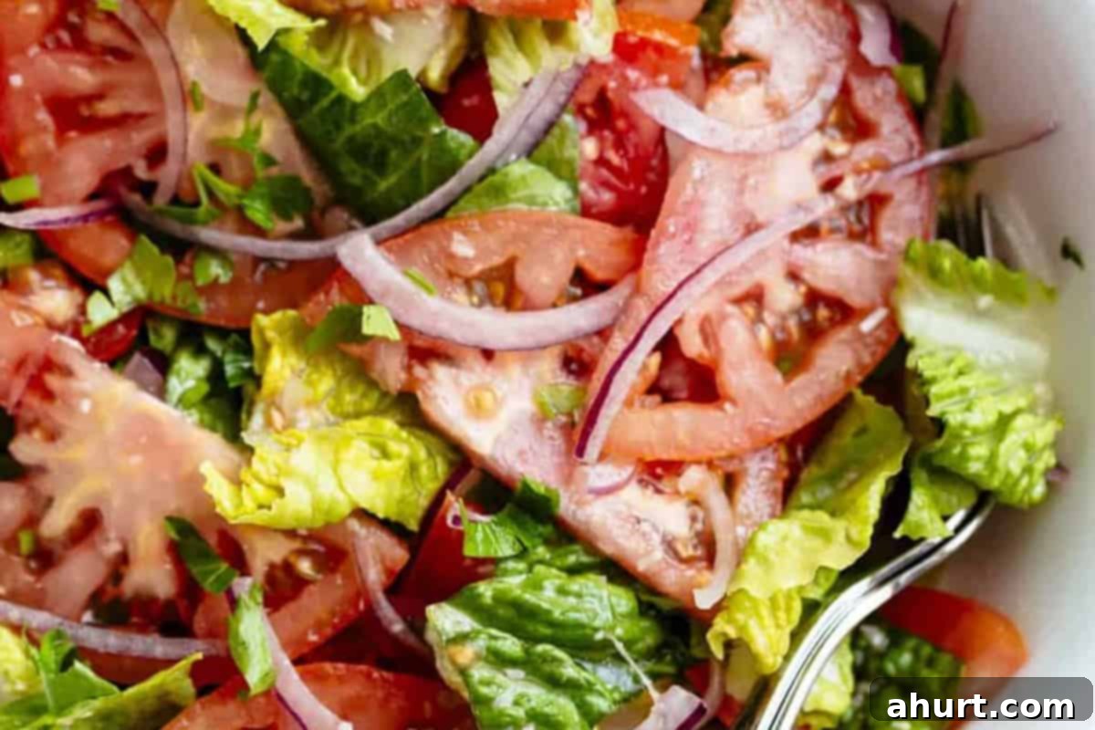 No-Fuss Tomato Salad 5 Step 2: Close-up of Easy Tomato Salad being drizzled with homemade Lemon Parmesan Vinaigrette just before serving.