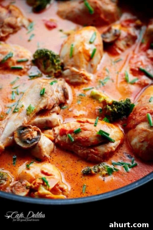 Zoom in image of Creamy Tomato Chicken Drumsticks in a rich red sauce, garnished with fresh herbs.