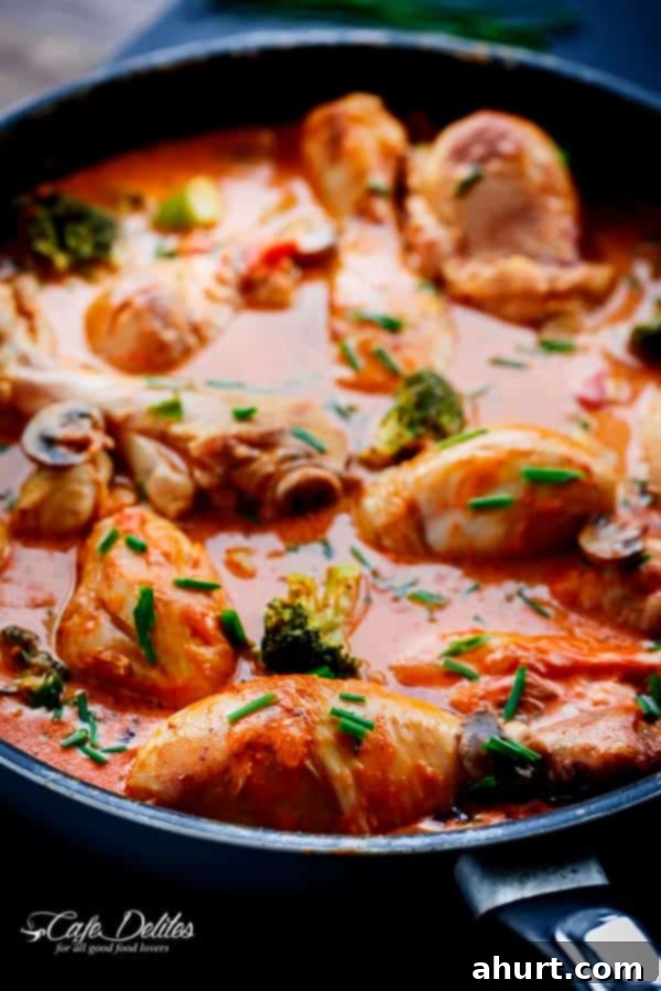 Spicy and Creamy Tomato Chicken Drumsticks with a vibrant red sauce and fresh green garnish.