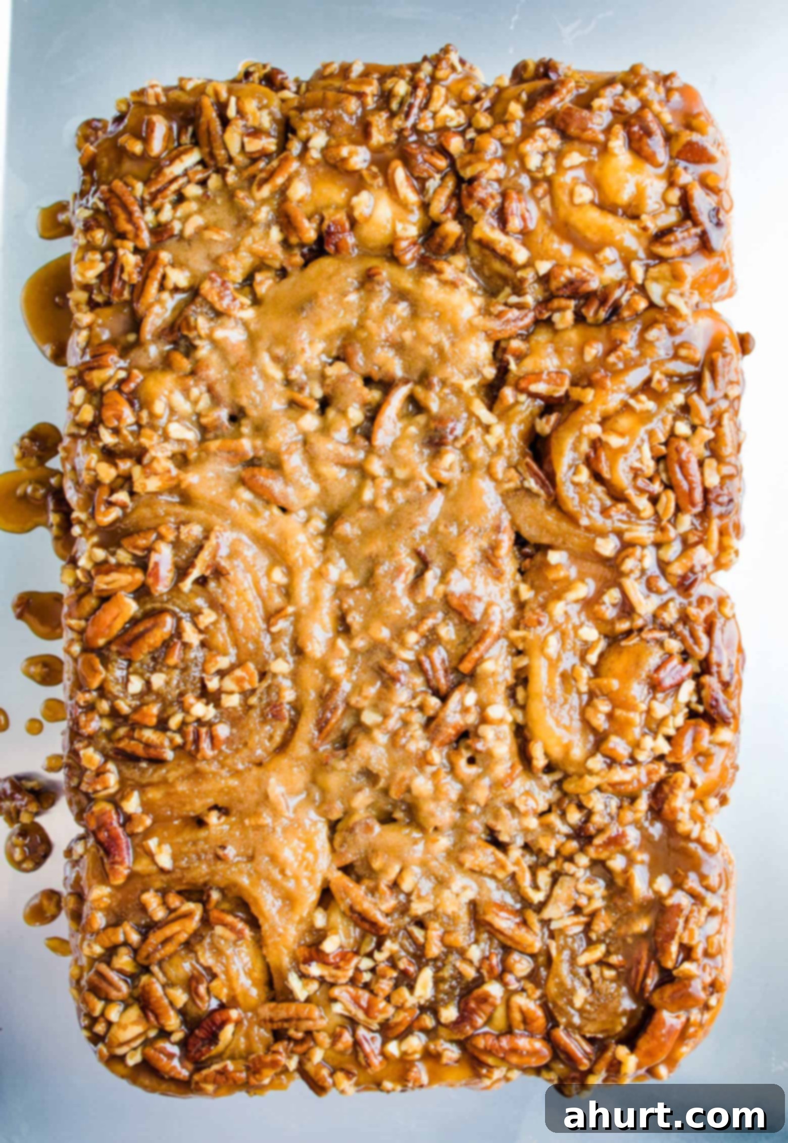 Top view image of soft, sweet, and sticky maple pecan buns on a baking sheet.