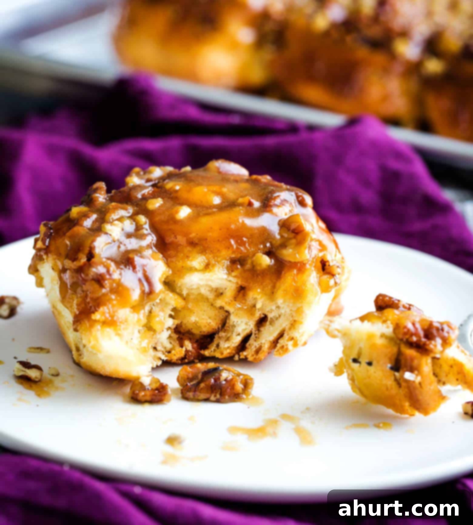 Plate of maple pecan sticky buns, soft, sweet, and sticky, garnished with fresh mint.