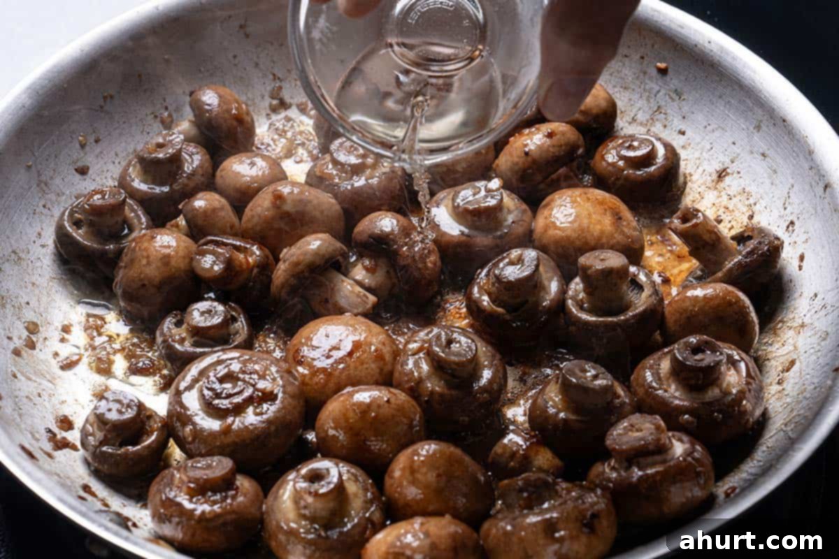 Golden Garlic Butter Mushrooms 6 Image of wine being added to the pan.