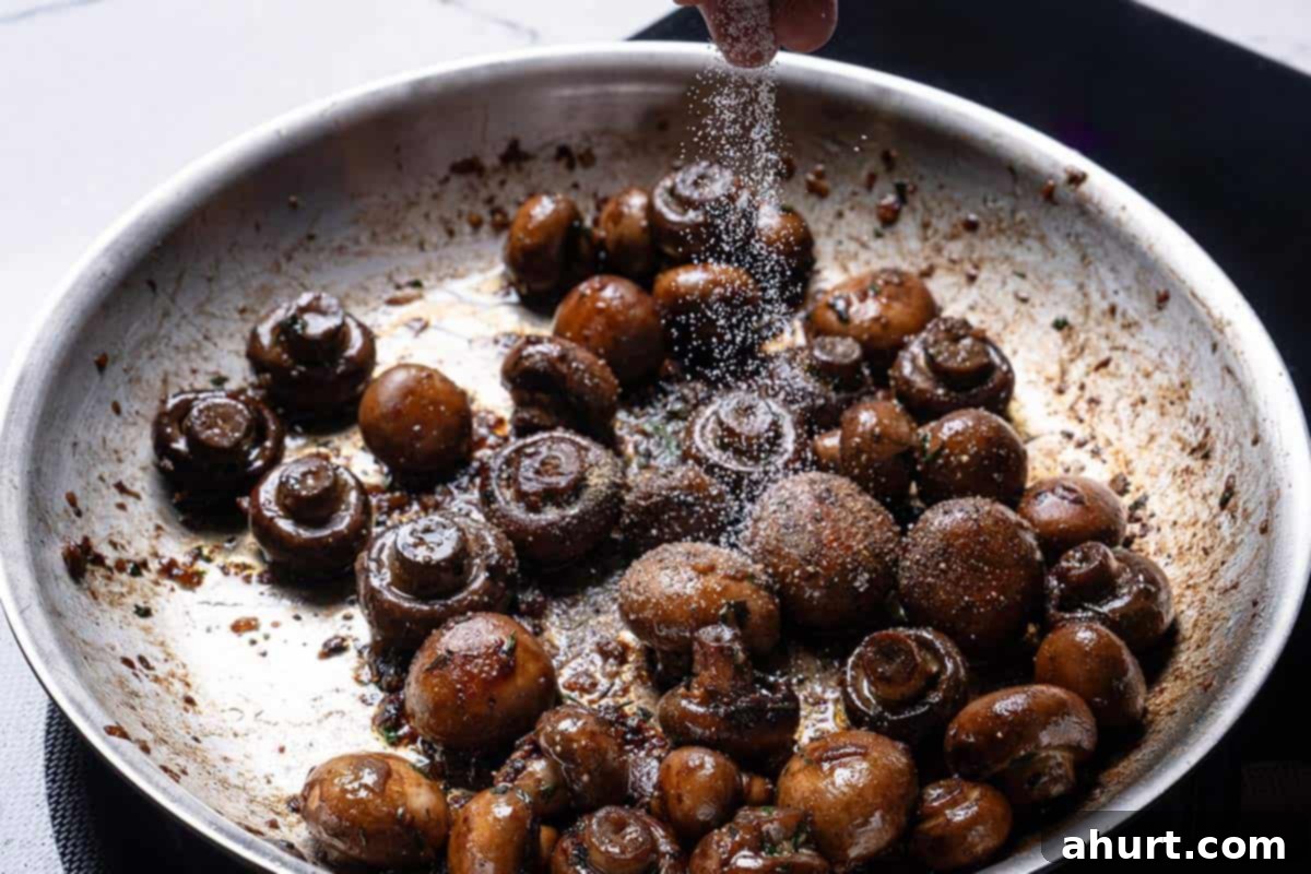 Golden Garlic Butter Mushrooms 8 Image of salt being added to the pan.