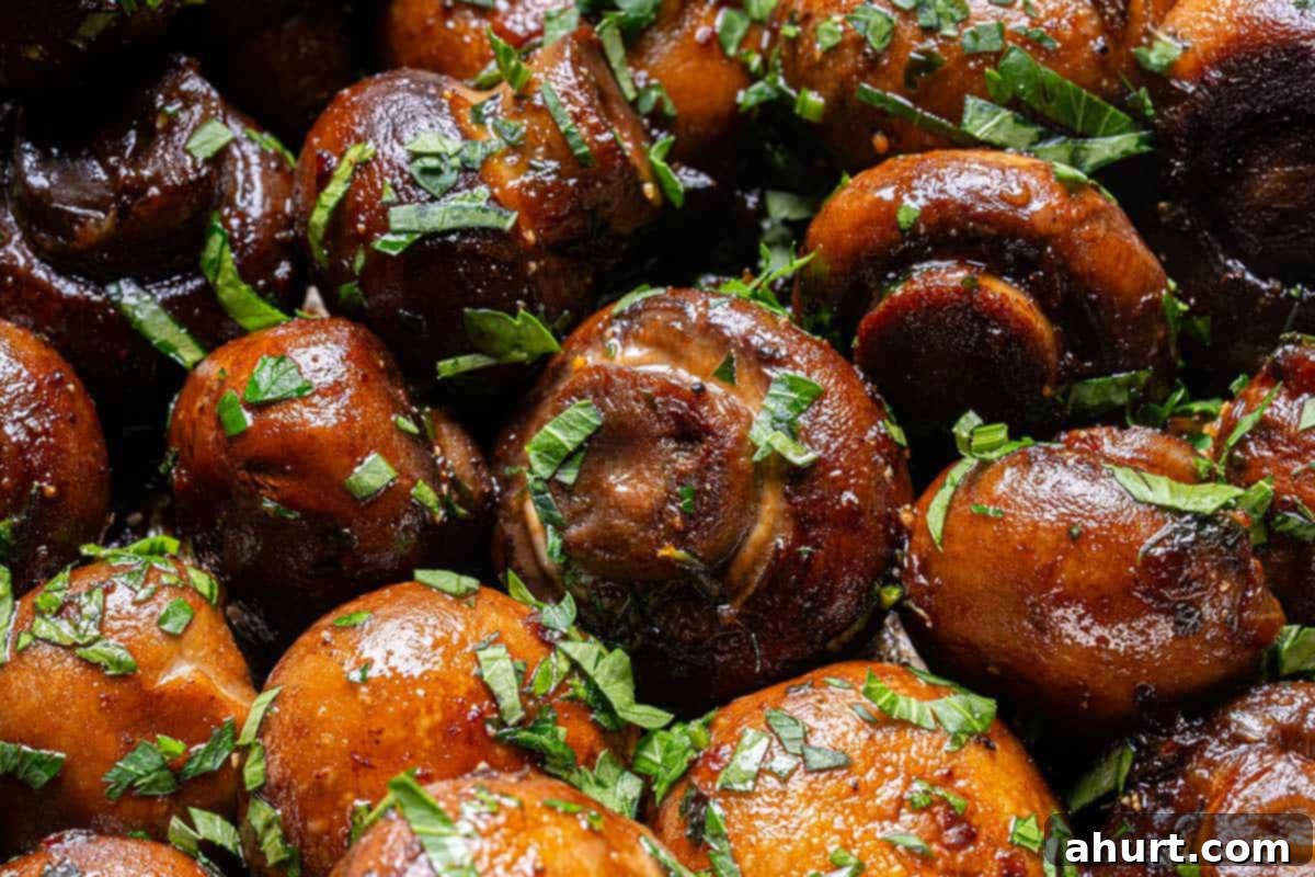 Golden Garlic Butter Mushrooms 9 Close up image of buttery garlic mushrooms coated in parsley.