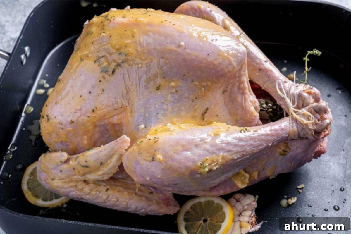 Perfect Herb Butter Roasted Turkey 6 moist turkey bathed in herb butter mixture in a dish with garlic and lemon