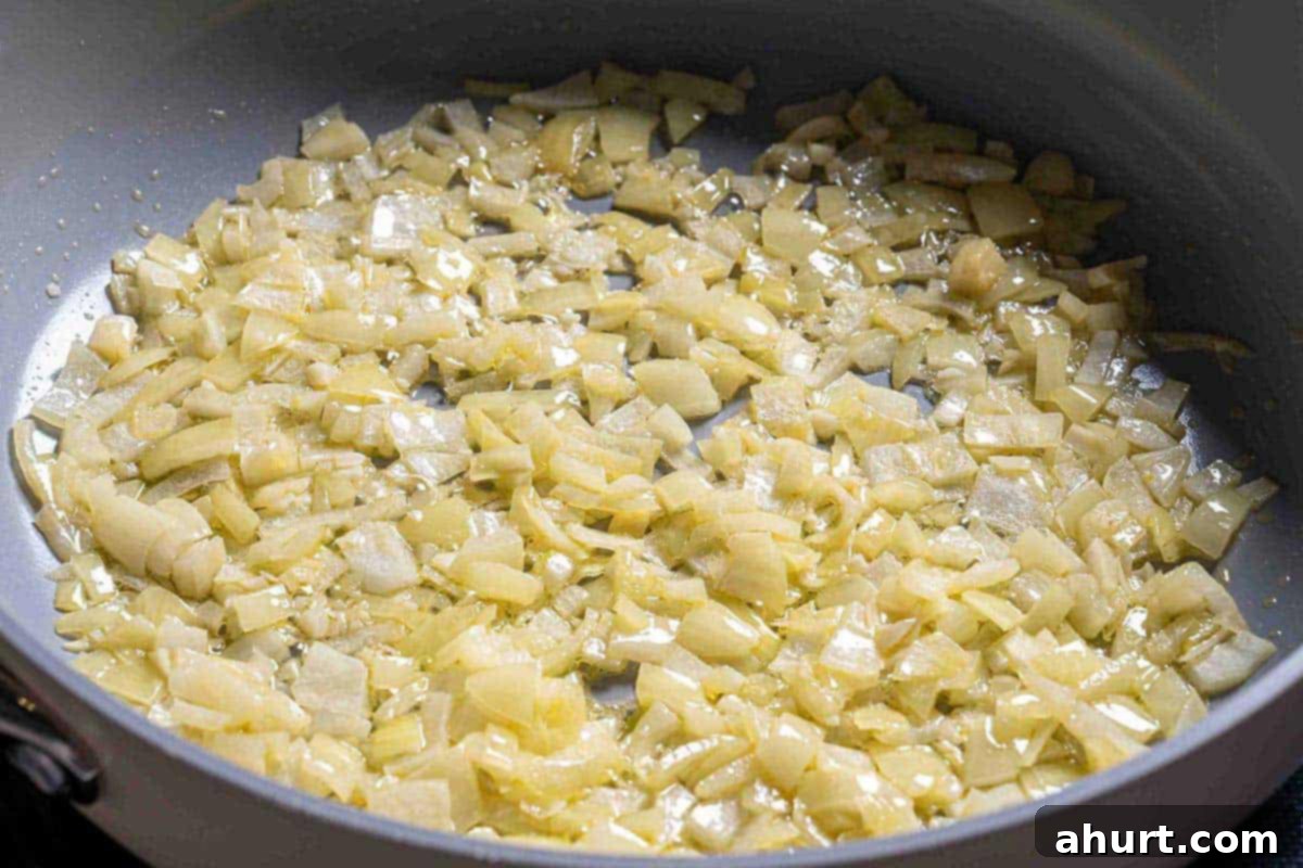Velvety Green Bean Casserole with a Golden Crunch 5 diced onions being sautéd in a pan